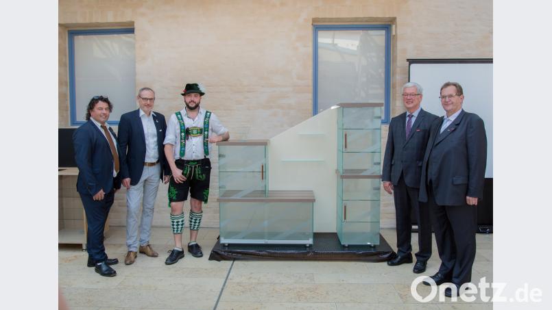 Stolz präsentiert der Kursbeste Tim Trottmann (Dritter von links) den Ehrengästen (von links) stv. Landesinnungsmeister Guido Carniato, Landesinnungsmeister Thomas Strobl, HWK-Vizepräsident Karl-Heinz Moser und Leiter des Bildungszentrums Josef Sailer sein Holz-Glas-Sideboard. Sein Meisterstück soll ab sofort den heimischen Wohnungsflur zieren. exb