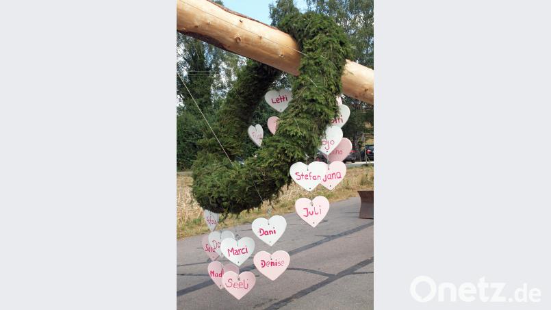 Herzen mit den Namen der Kirwamoidln und Kirwaburschen schmücken einen Kranz am Kirwabaum. sön