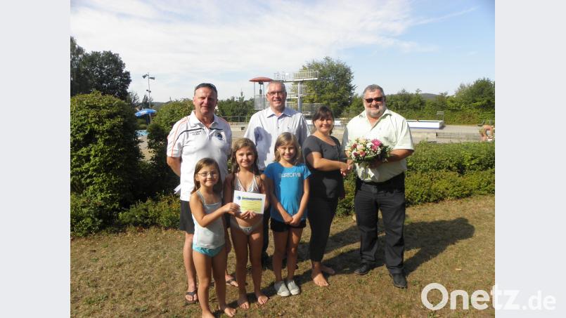 Kathrin Braun, die mit ihren drei Töchtern kam, war die 100 000. Besucherin im Freibad. Sie ehrten (von rechts) die Bürgermeister Armin Schärtl und Richard Tischler sowie Bademeister Norbert Wurmstein. Bild: pjom