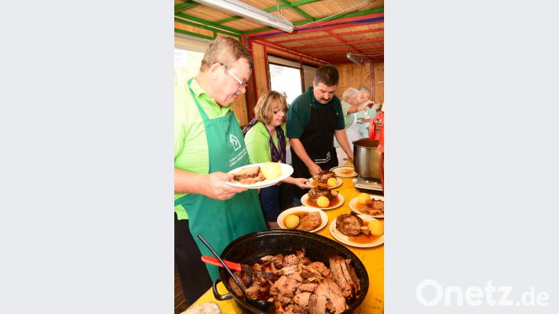 Zweiter Vorsitzender Artur Leonhardt, Roswitha Grünbauer und Vorsitzender Helmut Grünbauer bereiten die Schweinshaxen und den Schweinebraten zur Ausgabe vor. bey