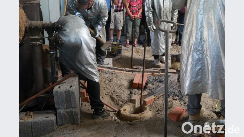Eine schweißtreibende Arbeit für die Glockengießer, die flüssige Bronze in die einzelnen Glockenformen zu leiten. njn