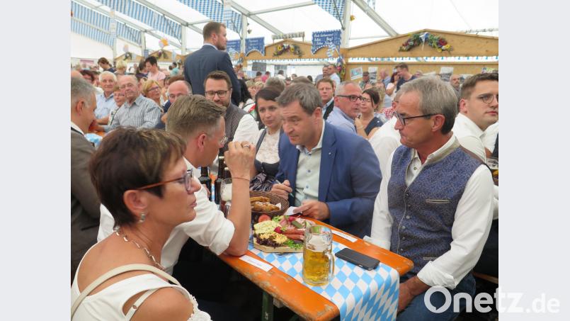 Am Biertisch tauschen sich Landtagsabgeordneter Tobias Reiß (vorne, Zweiter von links) und Ministerpräsident Markus Söder (ihm gegenüber) über weitere Möglichkeiten aus, die ländliche Region zu stärken. jzk
