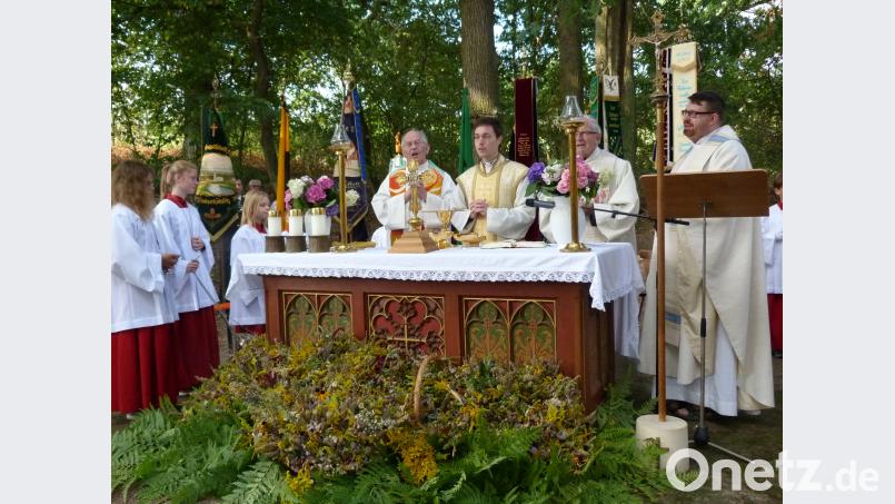 Beim Gottesdienst segnet Pfarrer Stephan Rödl die Kräutersträußchen vor dem Altar . hok