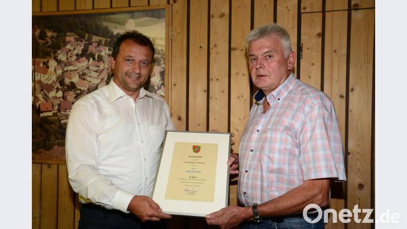 Bürgermeister Anton Kappl (links) überrreicht dem ausscheidenden Marktrat Josef Zitzmann eine Dankurkunde. bey
