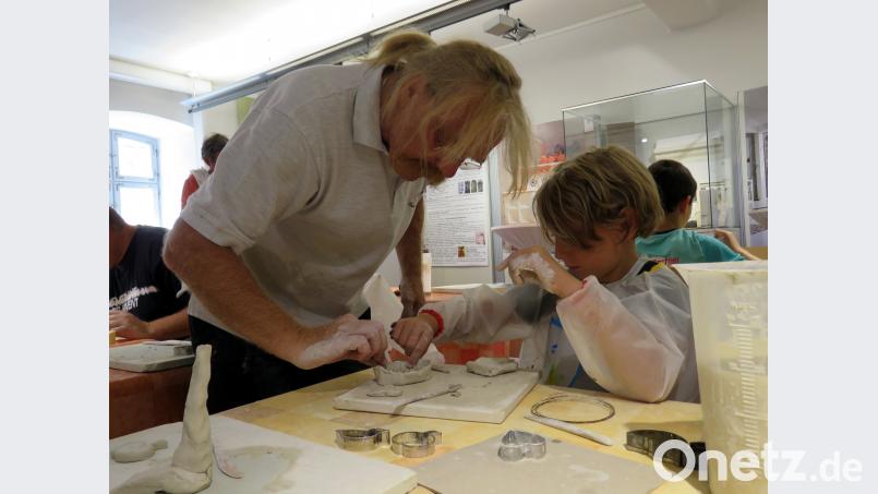 Marie braucht Hilfe. Josef Regner zeigt ihr, wie das Vogelnest aus Ton stabiler wird, damit nichts abbricht beim späteren Brand im Brennofen. ubb