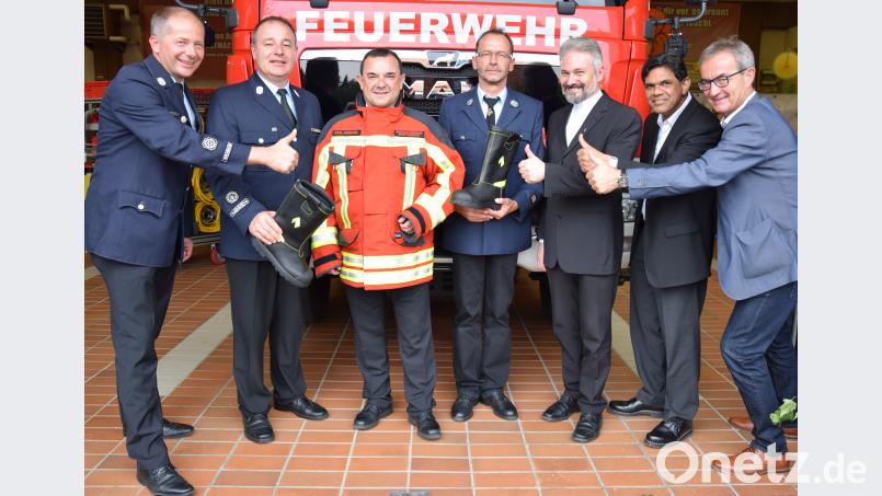 Vorsitzender Roman Schäffler und Kommandant Peter Denz (von links) sowie stellvertretender Kommandant Alfred Vogel (Vierter von links) übergeben die Schutzkleidung an Stadtpfarrer Konrad Amschl (Dritter von links), damit dieser sein neues Amt gut ausführen kann. Bürgermeister Werner Nickl, Pfarrvikar Joseph Meenpuzhackal und der evangelische Pfarrer Dirk Grafe sind froh über das Engagement. mde