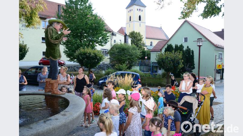 Hoch auf dem Beckenrand des Stadtbrunnens erzählt Johannes Rupprecht das Märchen vom „gestiefelten Kater“. Er hat dafür und auch für das Märchen „Der Teufel mit den drei goldenen Haaren“ den Text geschrieben. bey