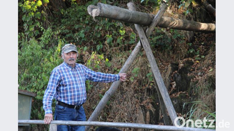 Paul Schmidbauer am ausgetrockneten Lohbach. Normalerweise fällt hier das Wasser etwa drei Meter vom Hang herunter. Über den ausgehöhlten Stamm wird der Teich mit Frischwasser versorgt. upl