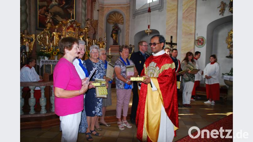 Pfarrer George Parankimalil dankt den ehemaligen Kirchenchor-Mitgliedern. enz