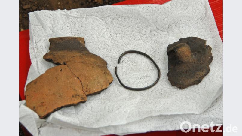 Bei der Einweisung der Kinder zeigte Dr. Hans Losert einige Fundstücke aus der diesjährigen Grabung.
Links ein Randstück einer karolingischen Keramik, zirka 1000 Jahre alt.
Rechts ein vorgeschichtliches Keramikfragment aus der Bronzezeit, zirka 3500 Jahre alt.
Mitte: Ein silberner Armreif aus Ungarn, zirka 1000 Jahre alt. Er wurde bereits im letzten Jahr gefunden. ow