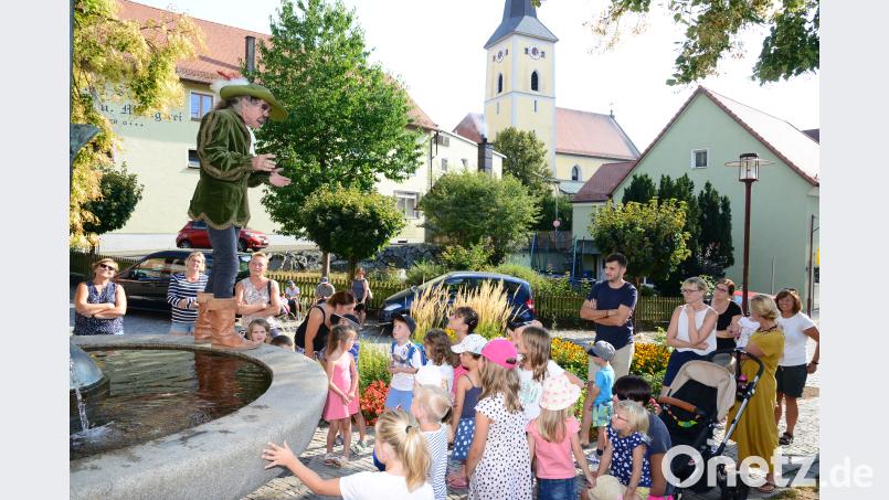 Hoch auf dem Beckenrand des Stadtbrunnens erzählt Johannes Rupprecht das Märchen vom „gestiefelten Kater“. Er hat dafür und auch für das Märchen „Der Teufel mit den drei goldenen Haaren“ den Text geschrieben. bey