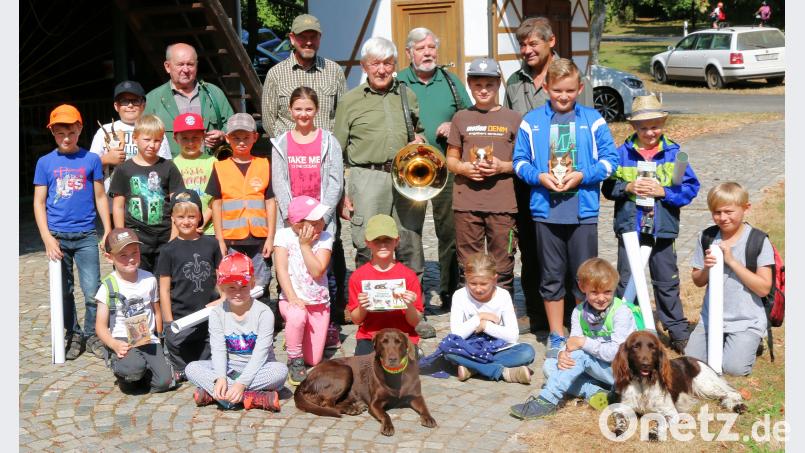 Viel Wissenswertes rund um die Jagd und das Wild erfuhren die Mädchen und Buben von Revierinhaber Hubert Rustler (hinten rechts) und den Jagdhornbläsern Otto Summer, Achim Grüner, Norbert Fleißner und Joachim Vollmer (hintere Reihe von links). Besonders ins Herz geschlossen hatten sie die Jagdhunde Linda und Mutz. kdi