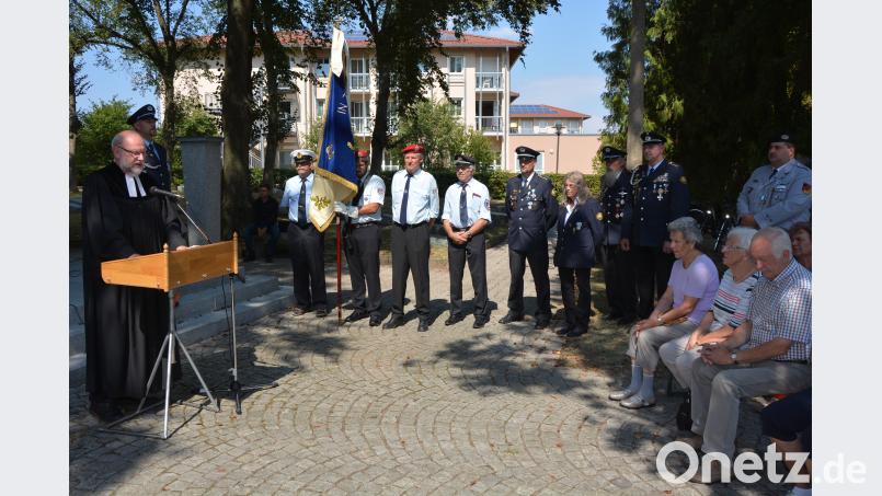 Pfarrer Martin Schlenk (links) bei seiner beeindruckende Rede vor dem Kriegerdenkmal. jr