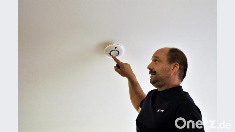 Thomas Mathes testet einen Rauchwarnmelder. Er legt auch Wert darauf, dass die Signalleuchte funktioniert. arw