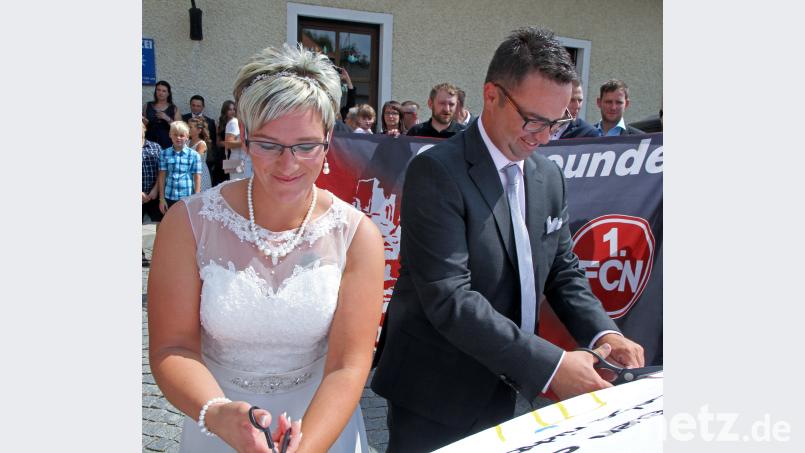 Ramona und Matthias Möschl schneiden vor dem Rathaus ein Herz aus. nm