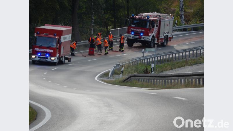 Schweißtreibender Einsatz bei hitzigen Temperaturen und prallem Sonnenschein: Die Einsatzkräfte regeln auf der B22 nahe Kemnath den Verkehr im Wechsel halbseitig und bringen Bindemittel auf. Dazu werden die Feuerwehrler auf der Straße durch Einsatzfahrzeuge abgesichert. Bild: mde