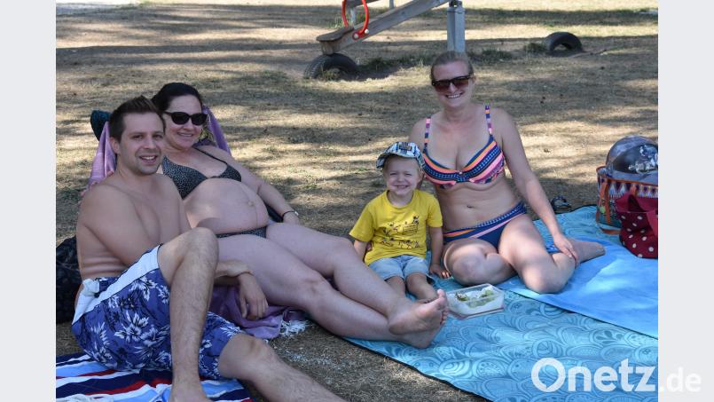 Christoph Biersack, Melanie Vezard und Juliane Bodensteiner mit Sohn Michael (von links) auf ihrem Stammplatz im Schätzlerbad. Die vier entspannen am Vormittag im Schatten. Bild: pens