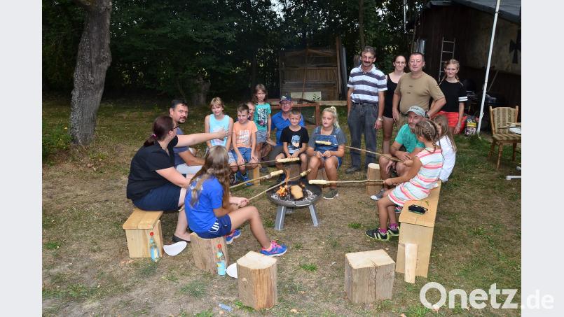 Die Kinder üben mit einem langen Stab, eigenes Brot herzustellen. Bild: fjo