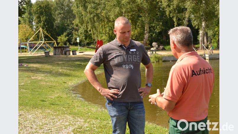 Björn Scheffczyk und Bademeister Andreas Baierl beim Natur- Kinderbad, für das sich viele Badbesucher feinen Sand statt Kies wünschen. Bild: hcz