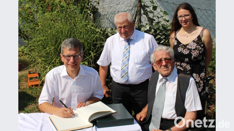 Pfarrer Johann Wutz (links im Bild) verewigte sich während der Feierlichkeiten im Goldenen Buch der Gemeinde. Bild: ema