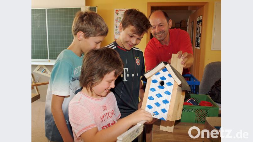 Ganz genau müssen die Kinder nach dem Muster-Nistkasten von Hans Ram (hinten rechts) die einzelnen Bretter ausmessen. Bild: sön