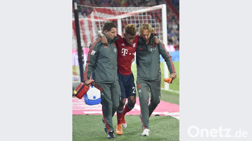 Gestützt von den Vereinsmedizinern wurde Bayerns Flügelflitzer in die Kabinen geführt. Kingsley Coman (Mitte) wird wegen eines Syndesmosebandrisses monatelang ausfallen. Bild: agentur_dpa