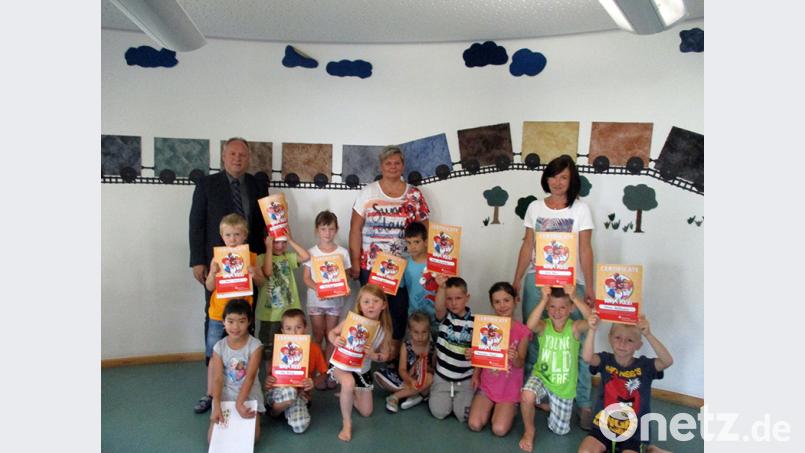Im Kindergarten St. Antonius in Kümmersbruck zeigen die Kinder mit Sparkassen-Filialleiter Hans Luschmann, Sabine Galli von der Kita-Leitung und Kursleiterin Claudia Röhrer ihre Zertifikate. Bild: exb