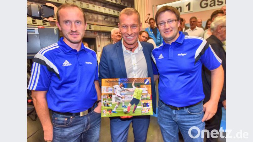 Mit einer Schautafel, die Markus Othmer in verschiedenen Szenen beim Hallenmasters des SVI zeigt, bedanken sich der Vorsitzende Martin Luber (links) und der Gesamtorganisationsleiter Holger Kellner (rechts) beim Moderator für die Möglichkeit, die Livesendung „Blickpunkt Sport“ im Studio mitzuerleben. Bild: no