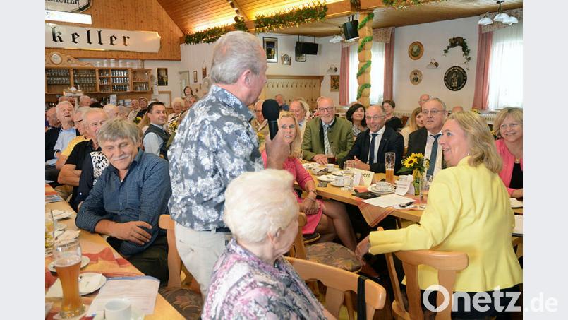 Erich Schieder, ehemals zweiter Bürgermeister von Floß, wagt die erste Wortmeldung bei der Fragerunde im Postkellersaal. Er will von Staatsministerin Kerstin Schreyer (im gelben Blazer) wissen, warum Supermärkte nicht verpflichtet sind, öffentliche Toiletten einzurichten. Von einer landesweiten Vorschrift hält die CSU-Ministerin jedoch wenig. Jede Kommune könne das für sich regeln oder eigene Lösungen finden, argumentiert sie. Bild: Schönberger