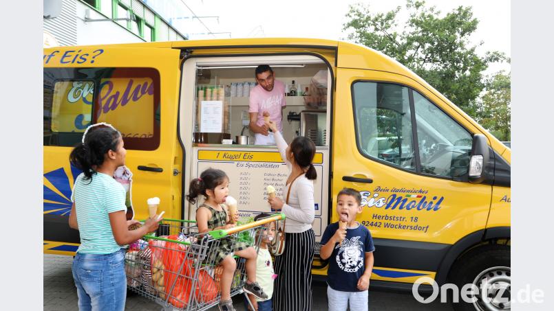 Mit insgesamt drei Eismobilen – einem organgen, einem weißen und einem gelben – ist Salvatore in der Region unterwegs. Bei den hohen Temperaturen, die es in den vergangenen Monaten gab, sind seine Eiskugeln sehr beliebt. Wie bei dieser Familie. Mama und Kinder bekommen jeweils eine Kugel: Mango, Schoko, Banane und Zitrone. Bild: Gerhard Götz
