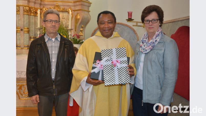Kirchenpfleger Reinfried Sußmann und Pfarrgemeinderatssprecherin Silvia Sußmann dankten dem scheidenden Pfarrer Dr. Cyprian Anyanwu mit Geschenken. Bild: jr