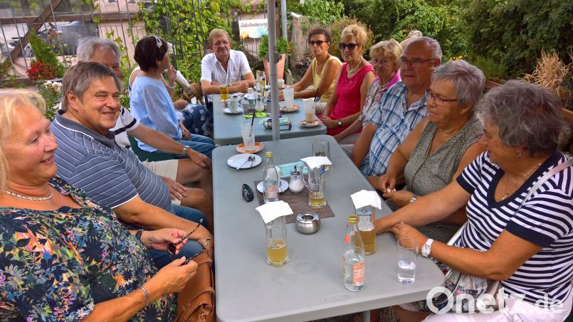 Die Stadtteilspaziergänger lassen den Abend im Gartencafé ausklingen. Norbert Schuller (hinten Mitte) referierte vorher über den Fischhofpark. Bild: exb