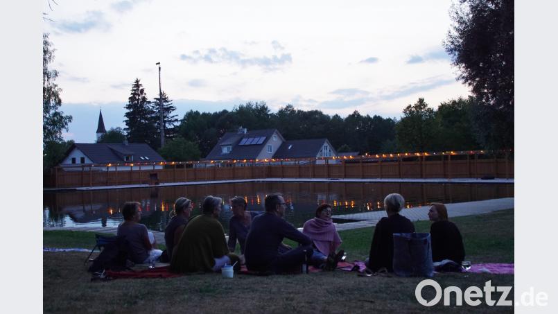 Ein ruhiger Platz auf der Liegewiese, bunte Lichter spiegeln sich im Wasser. Ein gemütliches Ambiente beim Sommerfest am Moorbadgelände. Bild: mmj