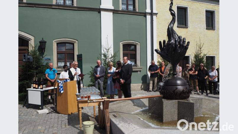 Pfarrer Herbert Zimmermann segnet den Granitbrunnen mit der Zoiglskulptur. Bild: gz