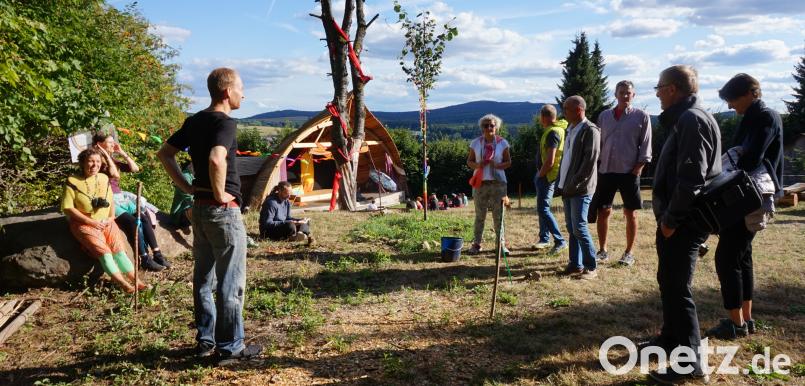Brigitte Schedler (sitzend links) und Christoph Dold (stehend Mitte) vom Vorstand im Gespräch mit Gästen am Tag der offenen Tür, im Hintergrund die kunstvoll gestaltete Open-Air Bühne. Bild: eib