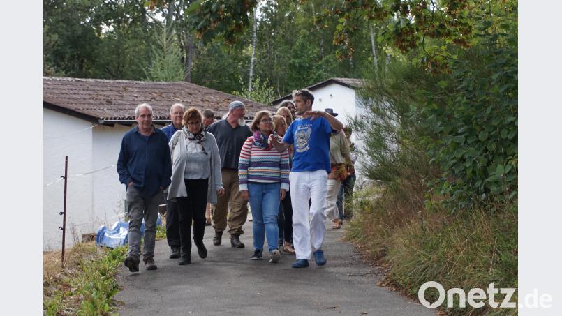 Führung durch das Areal, im Hintergrund zwei der Bungalows im ehemaligen Feriendorf. Bild: eib
