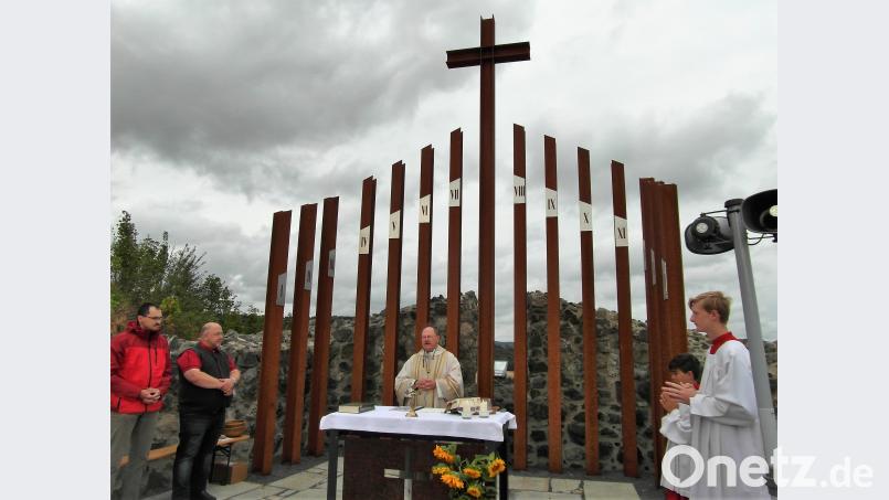 Pfarrer Heribert Stretz vor den Stelen der Kapelle beim Gottesdienst. Bild: hl
