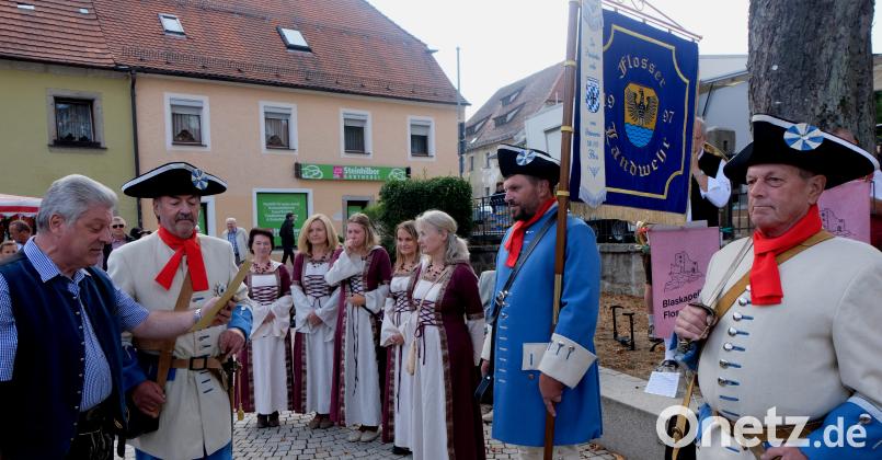 Der Oberste Dienstherr Bürgermeister Günter Stich und Hauptmann Franz Schmidt (von links) ernannten Roland Gmeiner (Mitte, mit Standarte ) zum Fähnrich der Flosser Landwehr. Bild: le