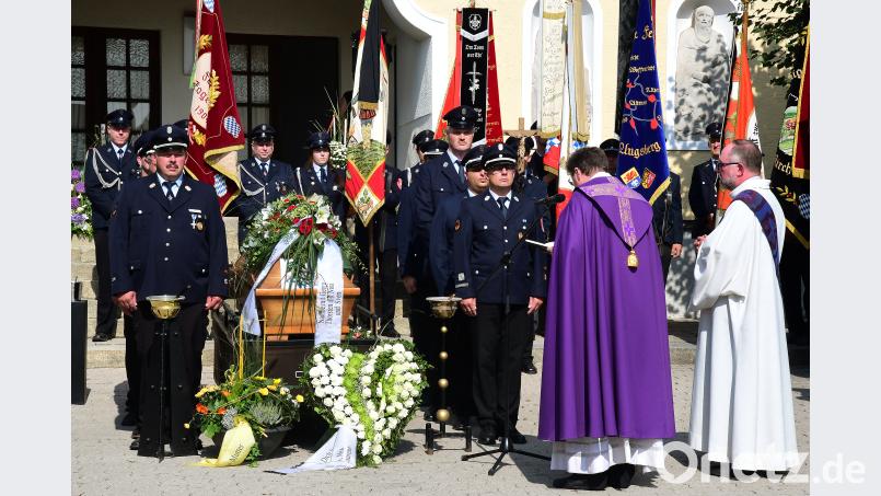 Bei der Verabschiedung von Peter Deiml auf dem Friedhof bilden die acht Kommandanten der Feuerwehren im Auerbacher Gemeindegebiet eine Ehrenwache am Sarg. Sie werden von den Fahnenabordnungen der 39 Wehren im Inspektionsbereich flankiert. Bild: Petra Hartl