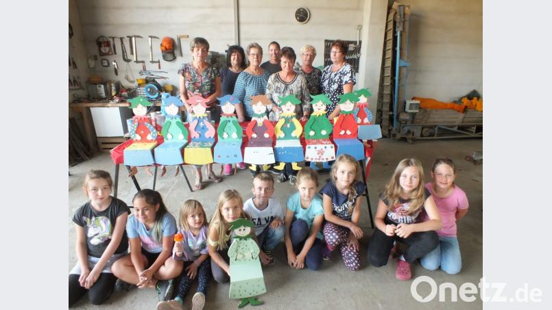 Stolz zeigen die Kinder ihre selbst gestalteten Kantenhocker, mit dabei Vorsitzende Inge Geißler (hi.3.v.li) und Mitglieder der Vorstandschaft des Gartenbauvereins Bild: soj