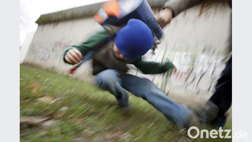 Die Gewalt an Schulen in Bayern hält sich in Grenzen: Ein Schüler drückt auf dem Schulhof eines Gymnasiums einen anderen zu Boden (gestelltes Illustrationsfoto). Bild: Oliver Berg/dpa