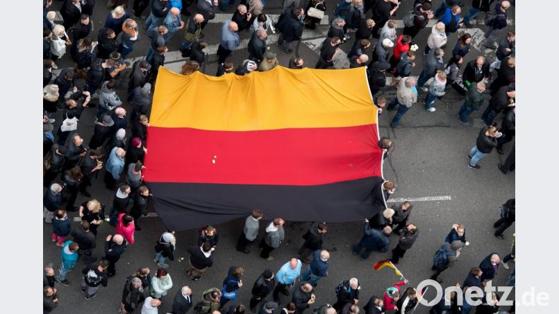 Teilnehmer der Demonstration von AfD, Pegida und Pro Chemnitz tragen eine große Deutschland-Fahne. Foto: dpa Bild: ---