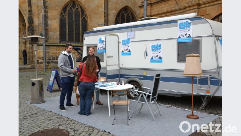Wenn es um Kinder und Jugendliche geht, denen geholfen werden kann, steckt Christian Michael Gnerlich (rechts mit dunkler Jacke) voller Ideen. Sein Brainboost-Neurofeedback-Mobil steht noch am Montag und Dienstag von jeweils 11 bis 18 Uhr vor der Basilika St. Martin auf dem Marktplatz. Bild: Thomas Kosarew
