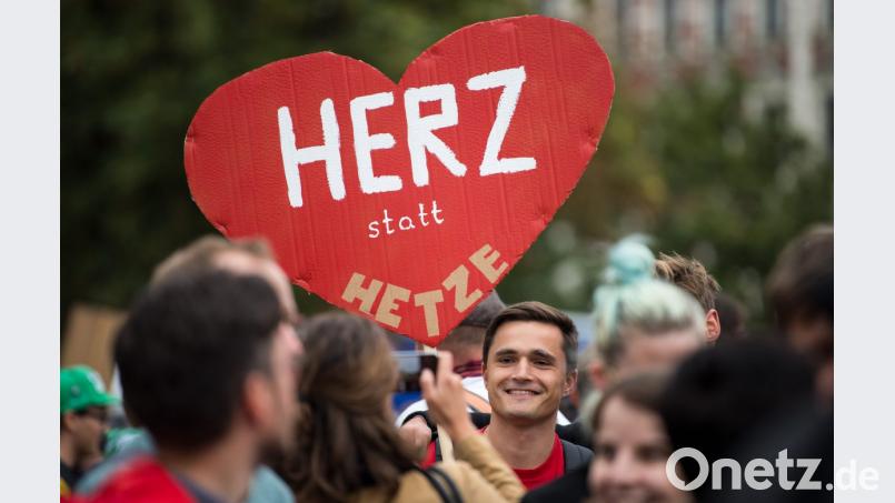 Ein Teilnehmer der Kundgebung des Bündnisses Chemnitz Nazifrei unter dem Motto "Herz statt Hetze" hält ein Schild in Form eines Herzen hoch. Bild: Monika Skolimowska/dpa