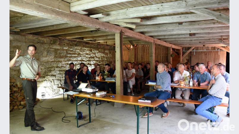 Revierförster Sebastian Höllerer (links) erläutert den Dorfgemeinschaften aus Kalmreuth und Schlattein die Vorteile eines neuen Forstweges auf der Trasse des bestehenden Schlatteiner Rundweges. Bild: bgm