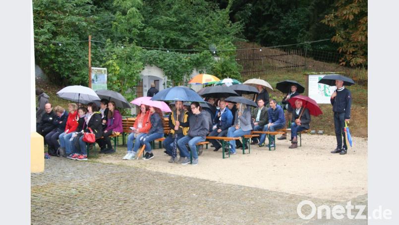 Trotz immer wieder einsetzender Regenschauer feiern etliche Gläubige den Gottesdienst auch vor der Kirche mit. Bild: swo