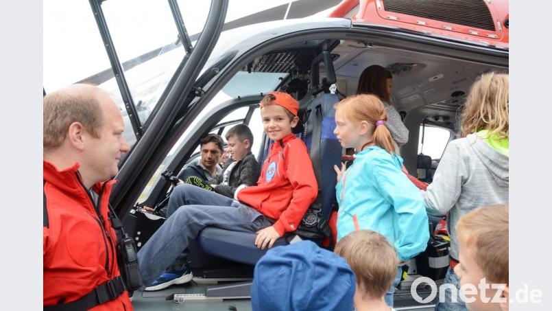 Martin Anz und sein Kollege Patrick Süttner (links) lassen die Kinder im Rettungshelikopter Probesitzen. Bild: gsb