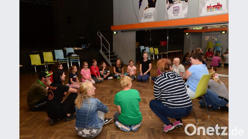 Erzieherin Ingrid Andes (im Hintergrund Mitte) befragt die Kinder zu Beginn des Workshops nach den Gründen für ihre Tanzbegeisterung. Bild: bey