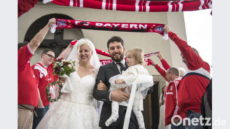 Die Mitglieder des Bayern-Fanclubs Neustadt stehen Spalier, als das Brautpaar mit Töchterchen Amelie aus der Kirche kommt. Bild: exb/Zaneta Weiden