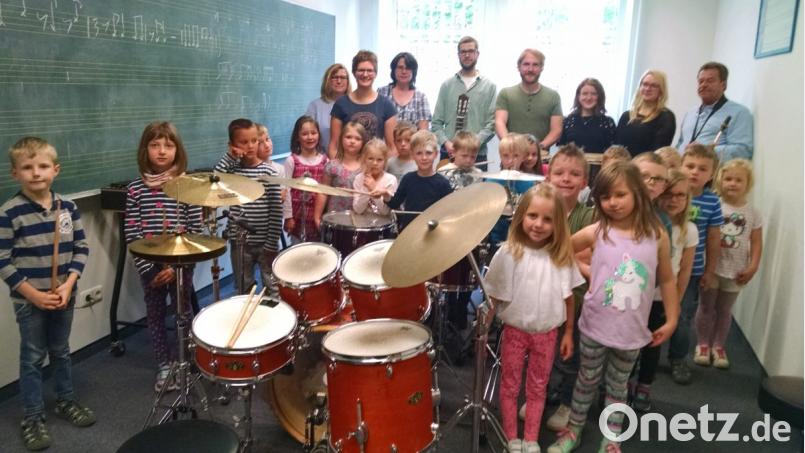 Die Leiterin des Kindergartens „St. Martin“, Theresa Uhl (stehend, Zweite von links) ist wie die Kids von den verschiedenen Instrumenten begeistert. Flugs schwingt sie sich aufs Drumset und zeigt den Kleinen ihre vielfältigen musikalischen Fähigkeiten. Bild: kwl